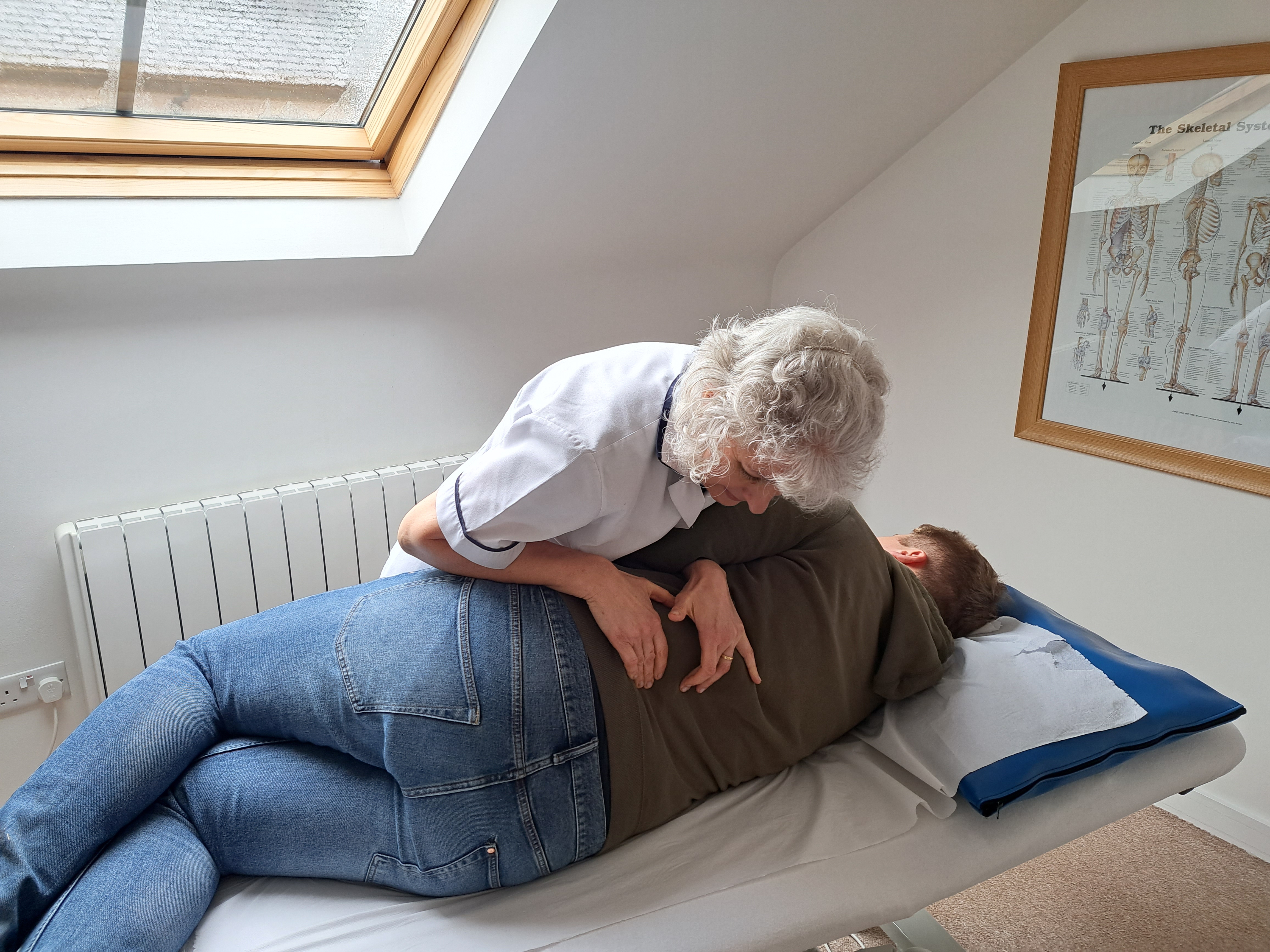 Person lying on treatment bed in Okehampton Osteopathic Clinic's treatment room